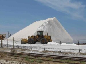 The impressive salt mounds dwarf a huge tractor.